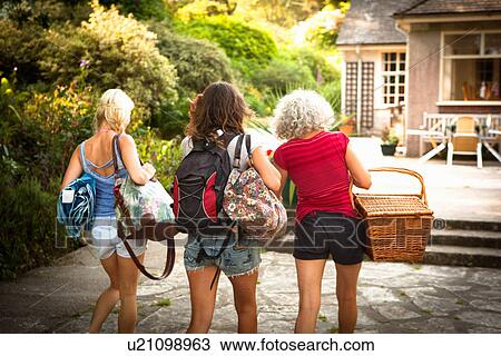 Rear view of mature mother and two daughters out walking with backpack and picnic basket View Large Photo Image Stock Image - Rear view of mature mother and two daughters out walking with backpack and picnic basket. Fotosearch