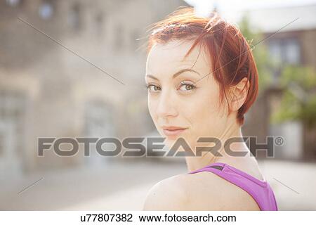 Stock Image - Red-haired woman in exercise top. Fotosearch