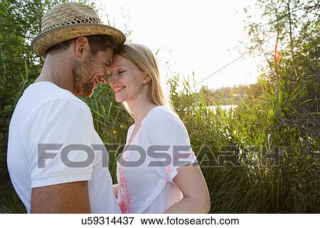 Stock Photo - Romantic mid adult couple at lakeside. Fotosearch