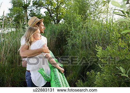 Romantic mid adult couple watching sunset at lakeside View Large Photo Image Stock Image - Romantic mid adult couple watching sunset at lakeside. Fotosearch