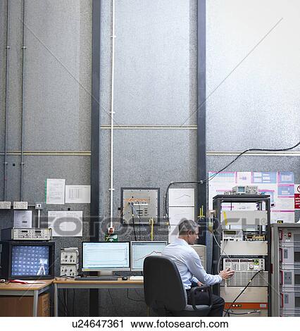 Stock Image - Scientist at work station of anechoic chamber. Fotosearch