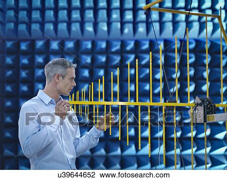 Stock Image - Scientist preparing to measure electromagnetic waves in anechoic chamber. Fotosearch