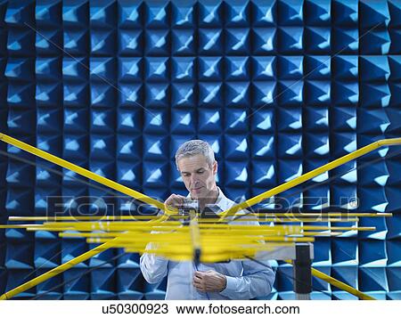 Stock Image - Scientist preparing to measure electromagnetic waves in anechoic chamber. Fotosearch