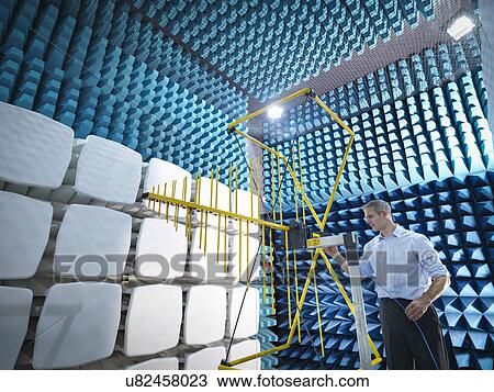 Stock Image - Scientist preparing to measure electromagnetic waves in anechoic chamber. Fotosearch