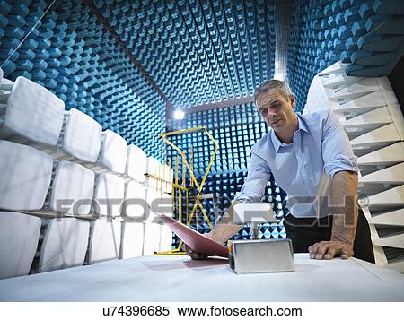 Stock Photography - Scientist preparing to measure electromagnetic waves in anechoic chamber, low angle view. Fotosearch