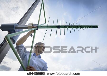 Scientist working outdoors with electromagnetic receiver aerial, low angle view View Large Photo Image Stock Image - Scientist working outdoors with electromagnetic receiver aerial, low angle view. Fotosearch