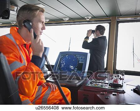 Ship worker using telephone and captain on ship's bridge View Large Photo Image Stock Photo - Ship worker using telephone and captain on ship's bridge. Fotosearch
