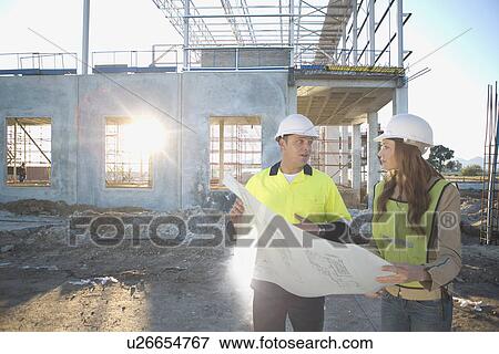 Stock Photo - Site manager and architect chatting about blueprint on construction site. Fotosearch