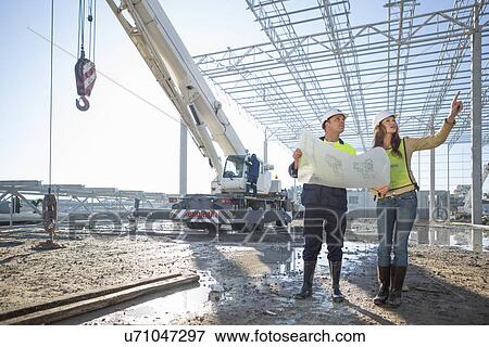 Site manager and architect checking blueprint on construction site View Large Photo Image Stock Photo - Site manager and architect checking blueprint on construction site. Fotosearch