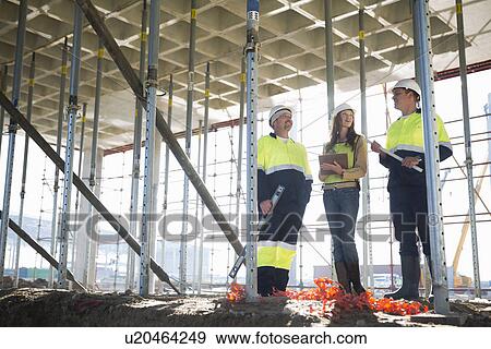 Stock Photo - Site manager and architects chatting on construction site. Fotosearch