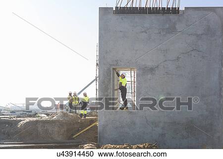 Stock Image - Site manager checking doorway on construction site. Fotosearch