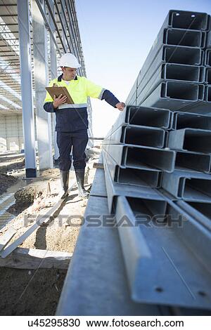 Site manager checking girders on construction site View Large Photo Image Stock Image - Site manager checking girders on construction site. Fotosearch