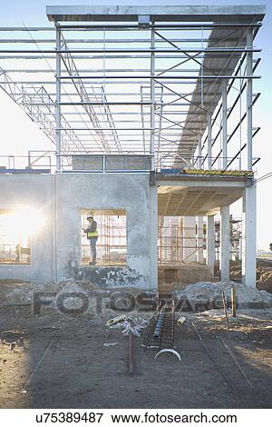 Site manager checking window frame on construction site View Large Photo Image Stock Photo - Site manager checking window frame on construction site. Fotosearch