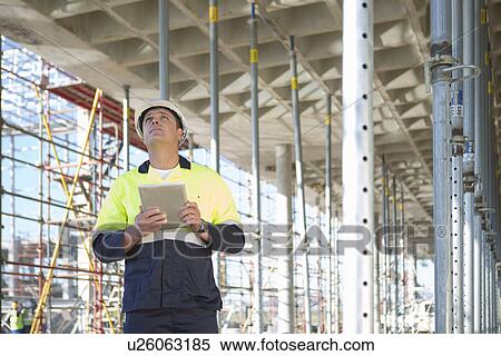 Stock Photography - Site manager using digital tablet on construction site. Fotosearch