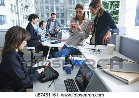 Six businessmen and women working in busy office View Large Photo Image Stock Image - Six businessmen and women working in busy office. Fotosearch