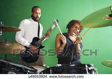 Picture - Students playing guitar and drums in college music room. Fotosearch