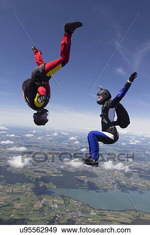 Team of two female skydivers in sit fly and head down positions over Buttwil, Luzern, Switzerland View Large Photo Image Stock Photo - Team of two female skydivers in sit fly and head down positions over Buttwil, Luzern, Switzerland. Fotosearch