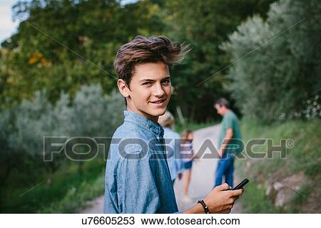Stock Image - Teenage boy with cell phone, portrait. Fotosearch