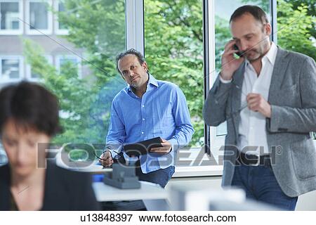 Three business colleagues working in busy office View Large Photo Image Stock Photo - Three business colleagues working in busy office. Fotosearch