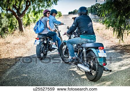 Stock Photo - Three friends and one dog on motorcycles, Cagliari, Sardinia, Italy. Fotosearch