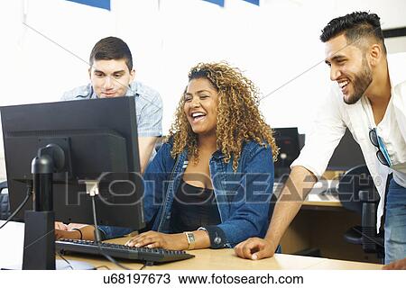Three student friends laughing and looking at personal computer in classroom View Large Photo Image Stock Image - Three student friends laughing and looking at personal computer in classroom. Fotosearch