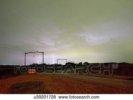 Stock Photo - Thunder clouds and lightning near railway track in dutch countryside. Fotosearch