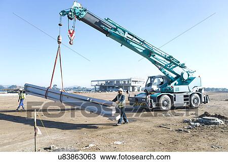 Two builders guiding girders on crane at construction site View Large Photo Image Stock Image - Two builders guiding girders on crane at construction site. Fotosearch