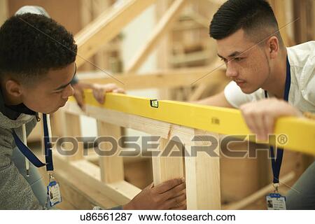 Two male college students using spirit level on frame in woodworking workshop View Large Photo Image Stock Photo - Two male college students using spirit level on frame in woodworking workshop. Fotosearch