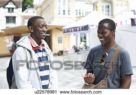 Two young male college friends chatting View Large Photo Image Stock Image - Two young male college friends chatting. Fotosearch