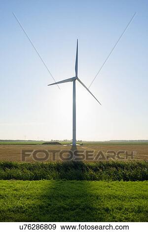 Stock Photo - Wind turbine in front of sunrise in field landscape, Rilland, Zeeland, the Netherlands. Fotosearch