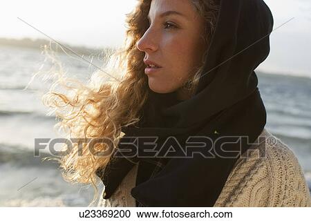 Woman all wrapped up on windy beach View Large Photo Image Stock Image - Woman all wrapped up on windy beach. Fotosearch