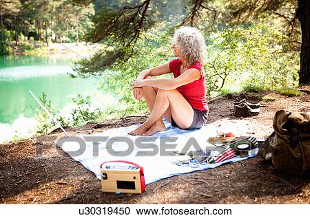 Stock Image - Woman by the Blue Pool, Wareham, Dorset, United Kingdom. Fotosearch