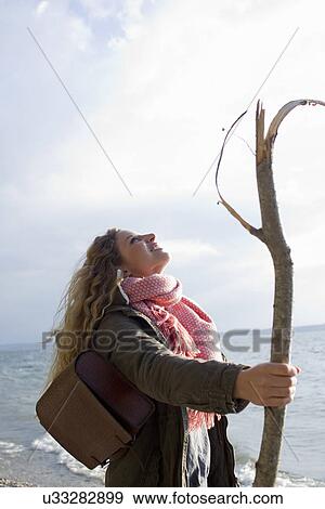 Woman by the sea with a large stick View Large Photo Image Stock Photo - Woman by the sea with a large stick. Fotosearch