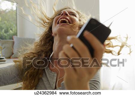 Woman dancing to music on smartphone View Large Photo Image Picture - Woman dancing to music on smartphone. Fotosearch