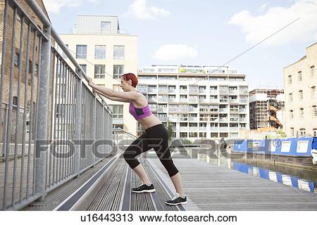 Woman doing stretching exercise, building in background, East London, UK View Large Photo Image Stock Image - Woman doing stretching exercise, building in background, East London, UK. Fotosearch