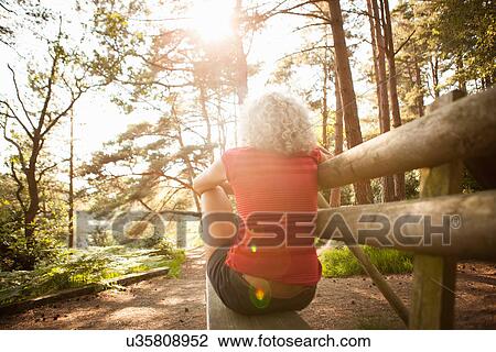Stock Image - Woman enjoying nature, The Blue Pool, Wareham, Dorset, United Kingdom. Fotosearch