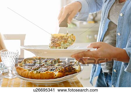 Stock Image - Woman holding plate serving flan. Fotosearch