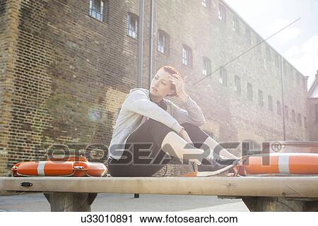 Woman in sports clothing, building in background View Large Photo Image Stock Image - Woman in sports clothing, building in background. Fotosearch