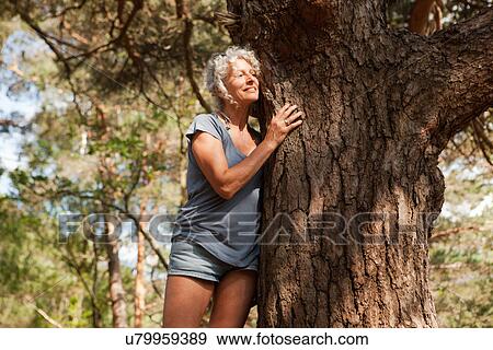 Woman leaning against tree trunk, The Blue Pool, Wareham, Dorset, United Kingdom View Large Photo Image Stock Photo - Woman leaning against tree trunk, The Blue Pool, Wareham, Dorset, United Kingdom. Fotosearch
