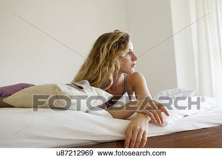 Woman lying in bed day-dreaming View Large Photo Image Stock Photo - Woman lying in bed day-dreaming. Fotosearch
