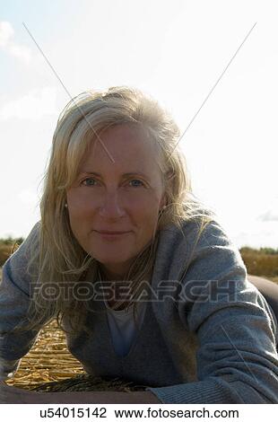 Stock Image - Woman lying on field. Fotosearch