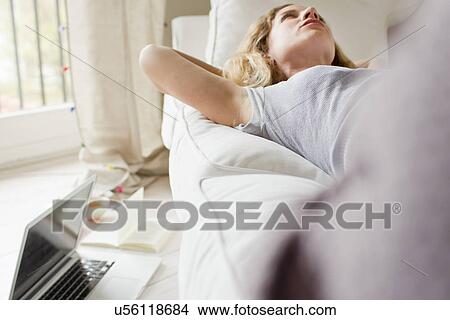 Woman lying on sofa day-dreaming View Large Photo Image Picture - Woman lying on sofa day-dreaming. Fotosearch