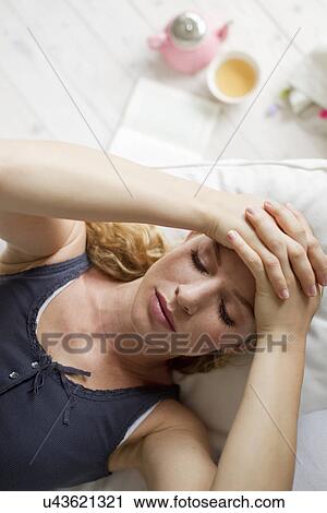 Woman lying on sofa with hands on head View Large Photo Image Stock Image - Woman lying on sofa with hands on head. Fotosearch