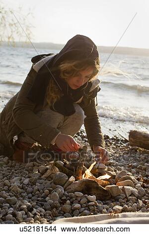 Woman making a fire by seaside View Large Photo Image Picture - Woman making a fire by seaside. Fotosearch