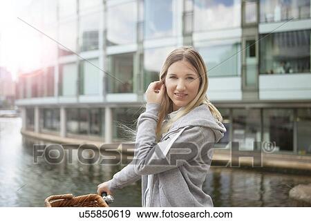 Stock Photo - Woman pushing bike along canal, East London, UK. Fotosearch