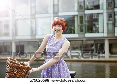 Woman pushing bike along canal, East London, UK View Large Photo Image Stock Photo - Woman pushing bike along canal, East London, UK. Fotosearch