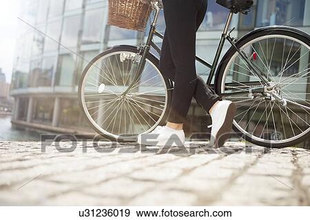 Stock Photo - Woman pushing bike along canal. Fotosearch