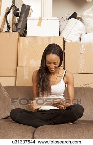 Woman sitting in flat surrounded by boxes View Large Photo Image Picture - Woman sitting in flat surrounded by boxes. Fotosearch