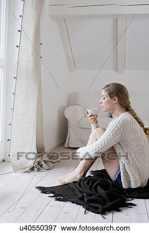 Woman sitting on floor drinking tea View Large Photo Image Stock Photo - Woman sitting on floor drinking tea. Fotosearch