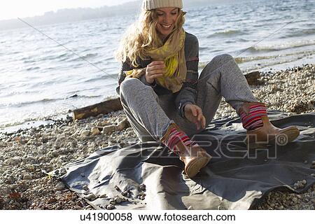 Woman sitting on windy beach View Large Photo Image Stock Photo - Woman sitting on windy beach. Fotosearch